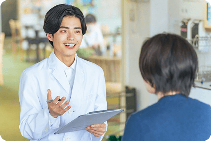白衣の薬剤師が患者さまと対話する様子