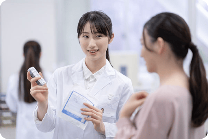 薬局のカウンターで患者さまに対応する薬剤師